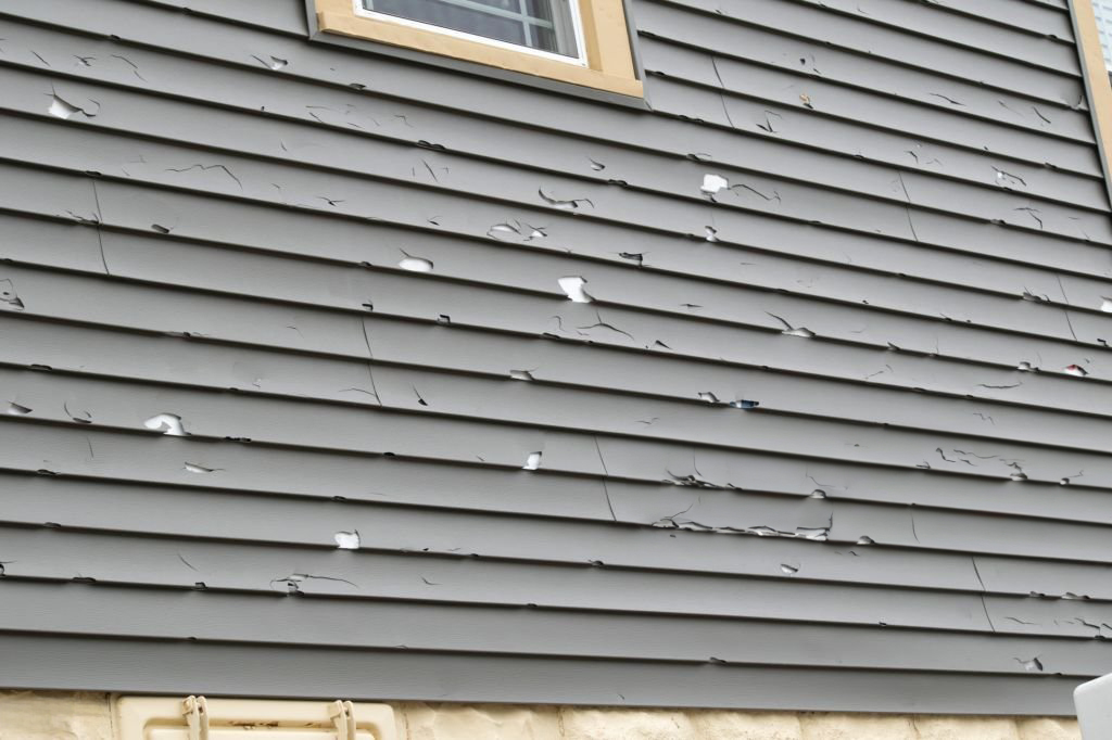 Home exterior in disrepair to roof, gutter, chimney, siding.